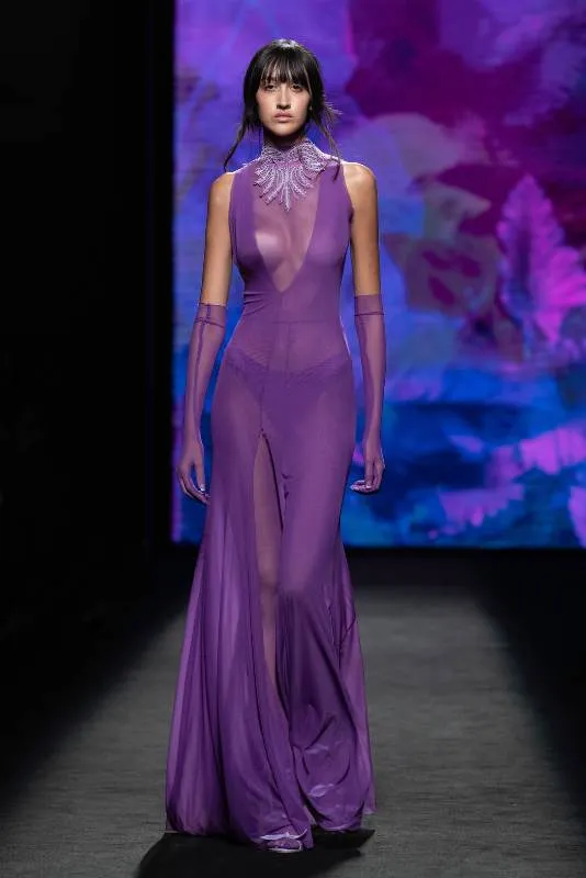 Modelo con vestido largo morado transparente en la pasarela de MBFW Madrid