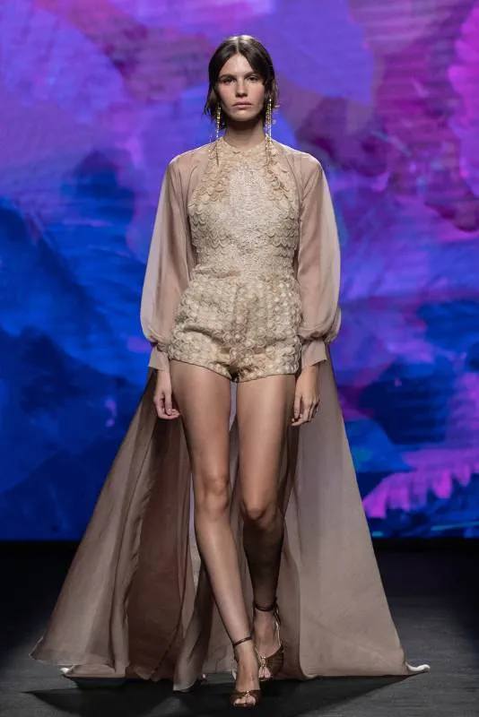 Modelo con mono corto de encaje y capa en la pasarela de MBFW Madrid
