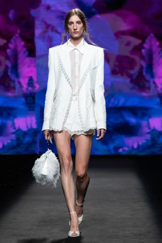 Modelo con traje blanco de chaqueta corta en la pasarela de MBFW Madrid