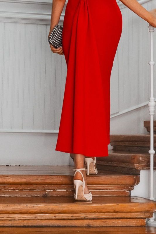 Invitada con vestido rojo subiendo una escalera con zapatos Inés R