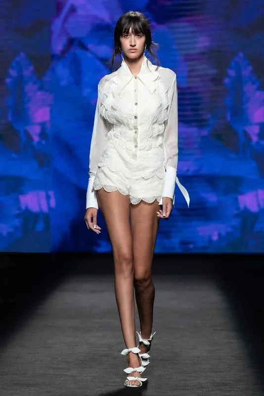 Modelo con conjunto blanco y sandalias con lazos en la pasarela de MBFW Madrid