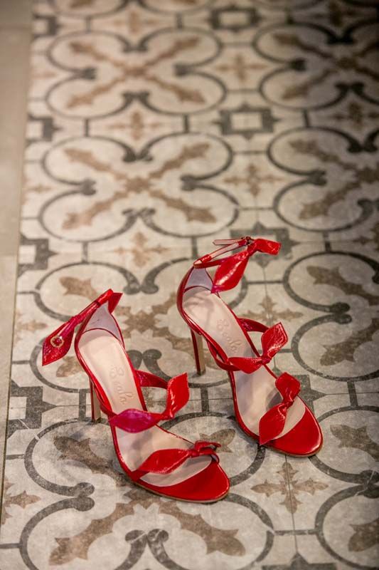 Sandalias París en charol rojo con lazos sobre suelo hidráulico