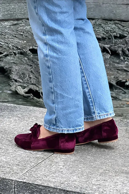 Mocasines de terciopelo burdeos con lazo y vaqueros