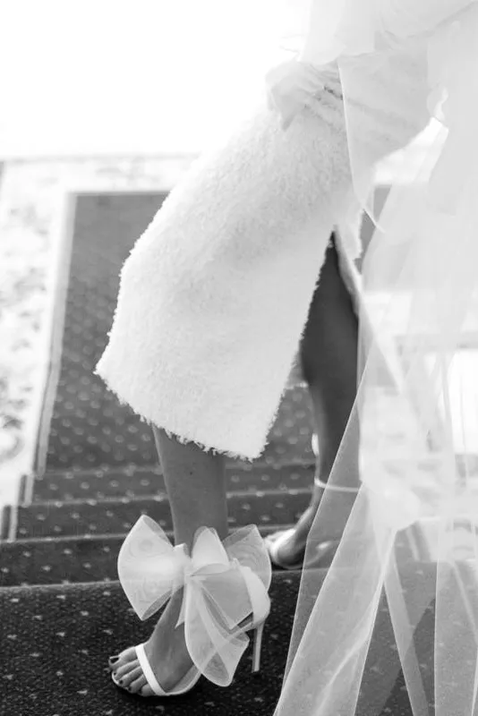 Novia con sandalias con lazo de tul en el talón, en blanco y negro